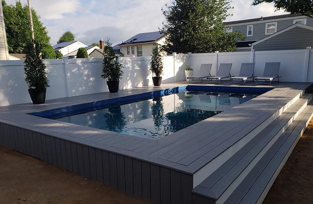 A pool with an elevated deck and patio.