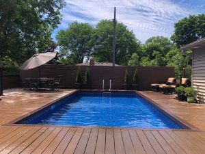 A pool with wooden deck and blue water