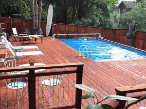 A pool with chairs and tables in the back ground