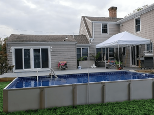 A pool with an umbrella in the back yard.