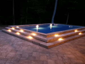 A pool with lights on the side of it