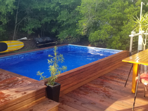 A wooden deck with an above ground pool