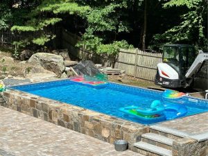 A pool with an inflatable slide and a ramp.