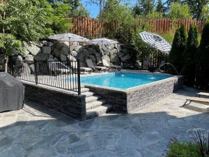 A pool with a fence and trees in the background