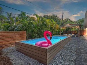 A pink flamingo float in the middle of an empty pool.